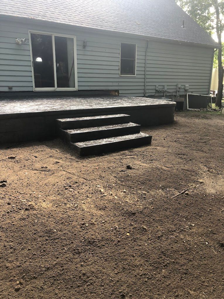 A house with a deck and stairs in front of it.