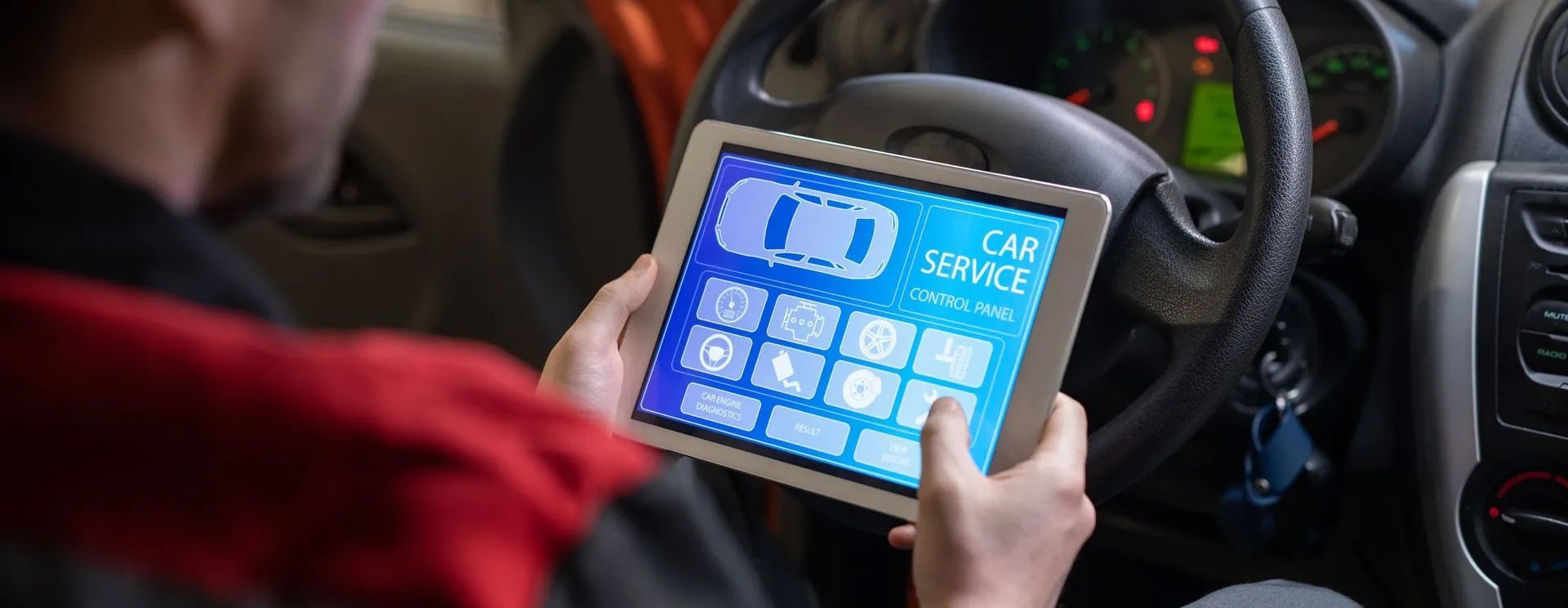 A man is using a tablet in a car.