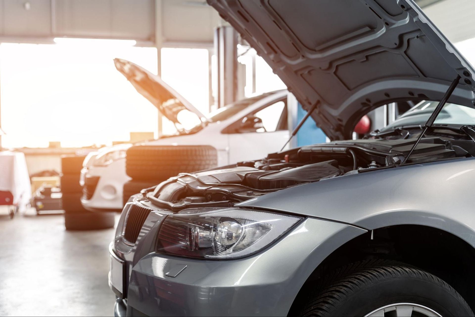 A car with its hood open in a garage.