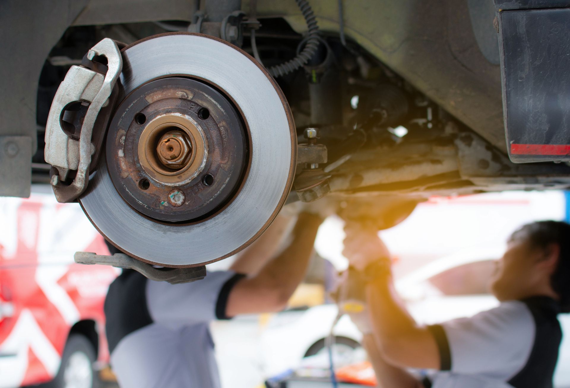 A man is working on the brake disc of a car.
