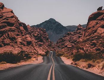 A road going through a canyon surrounded by rocks and mountains.