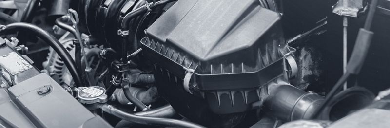 A black and white photo of a car engine being worked on.