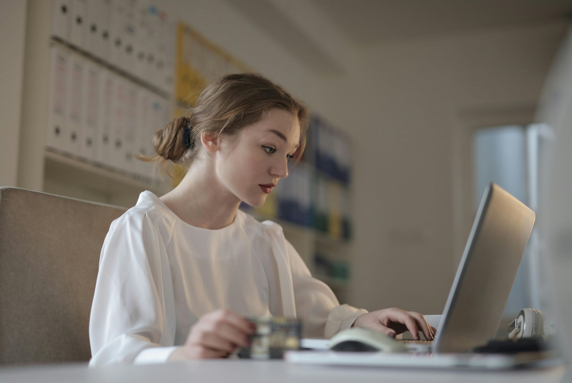 Person at desk having video call, notebook, books, and mug.