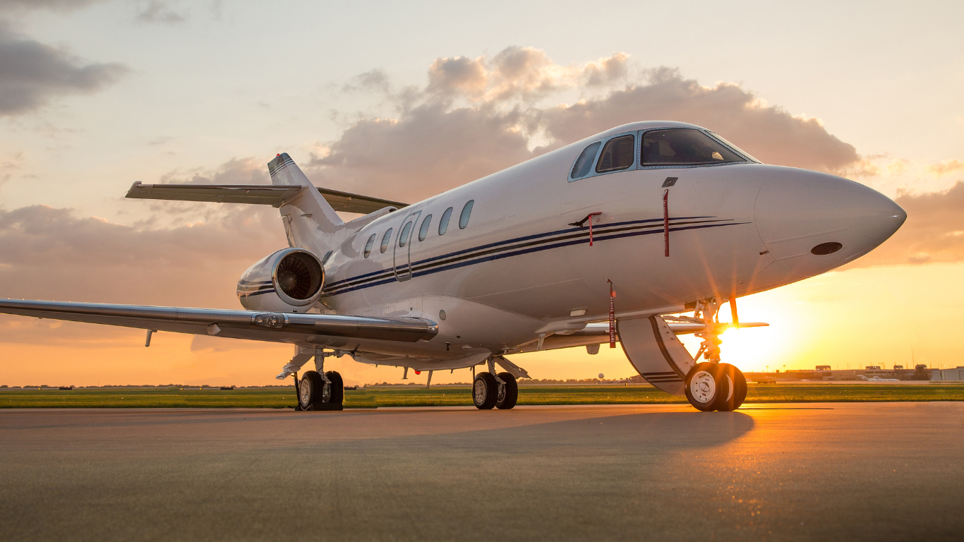 ein Privatjet steht auf einer Landebahn bei Sonnenuntergang