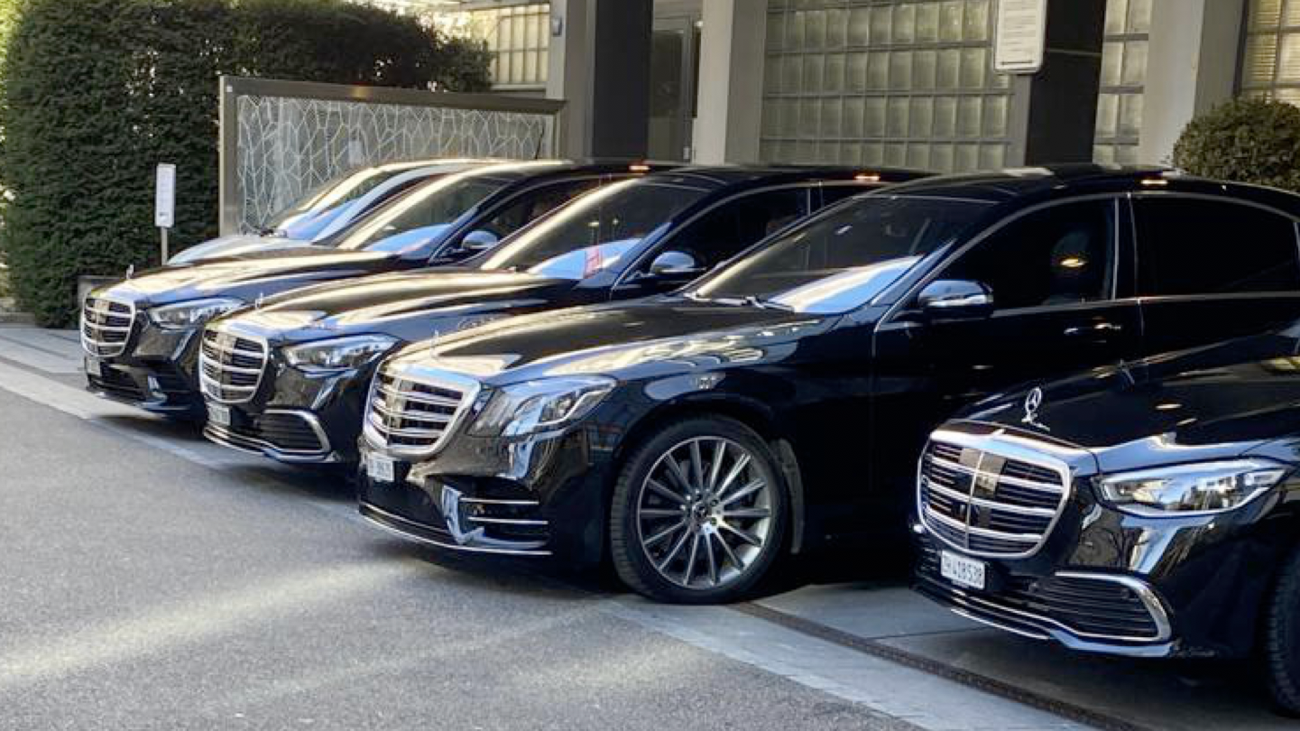 eine Reihe von schwarzen mercedes-benz-Autos auf einer Straße geparkt
