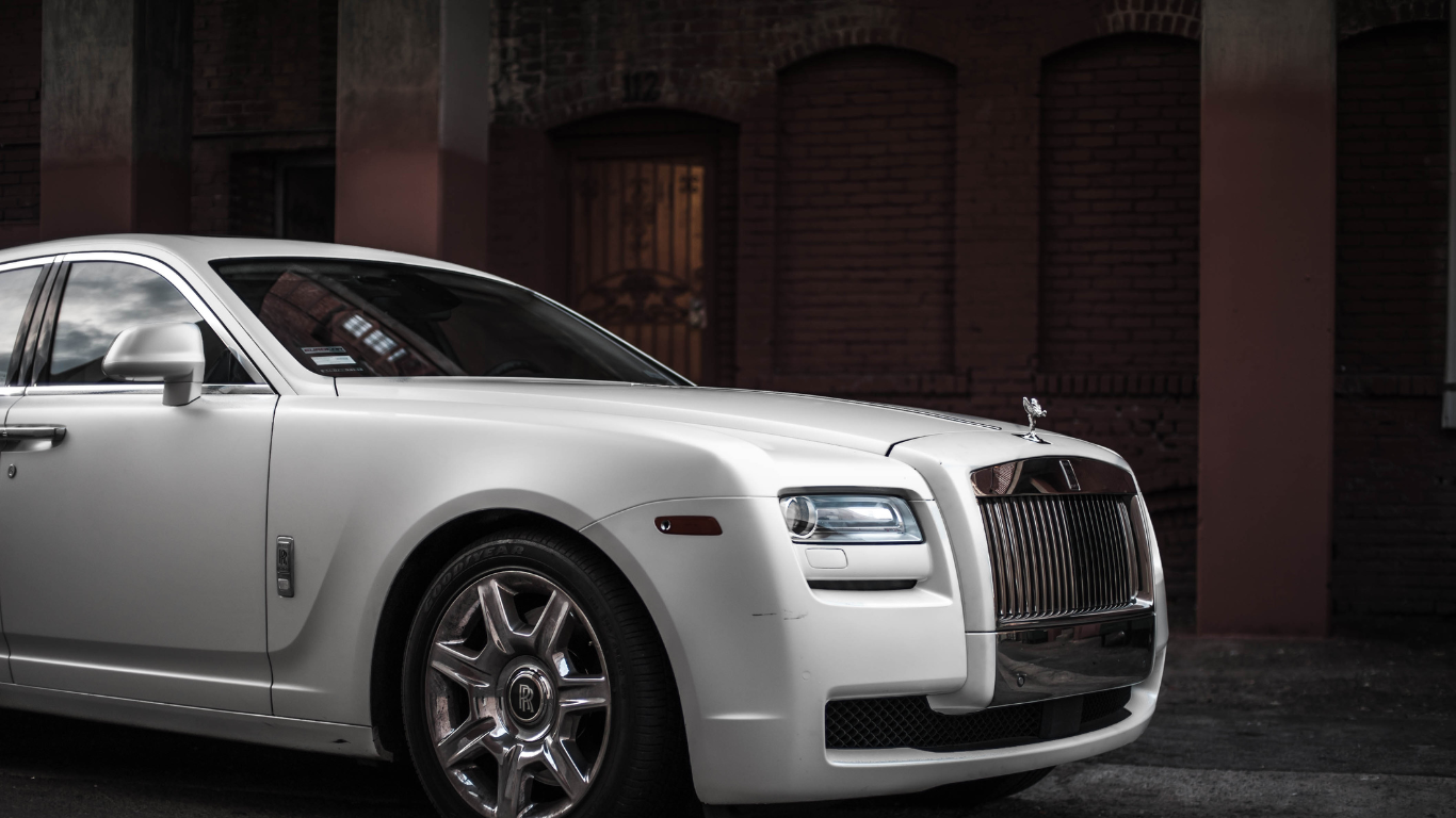 ein weißes Rolls-royce-Auto steht vor einem Gebäude