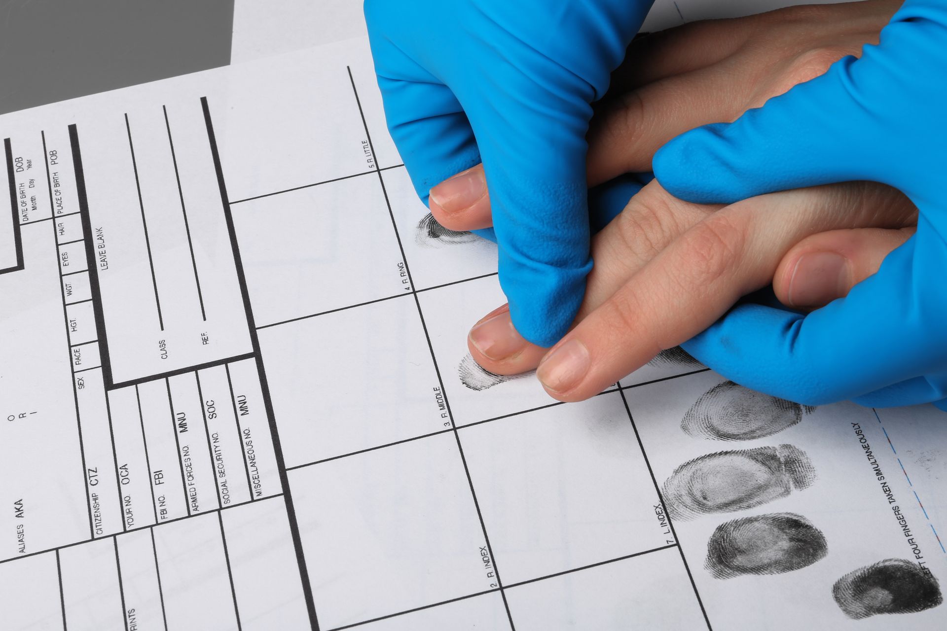 Person scanning their hand on a biometric scanner; at a counter.