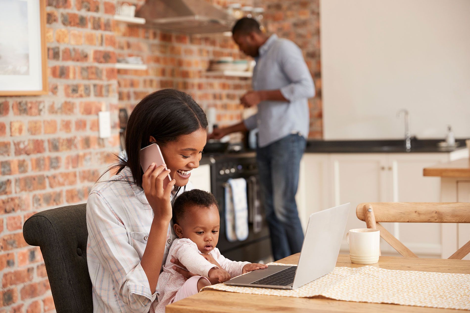 Woman working from home with a child on her lap