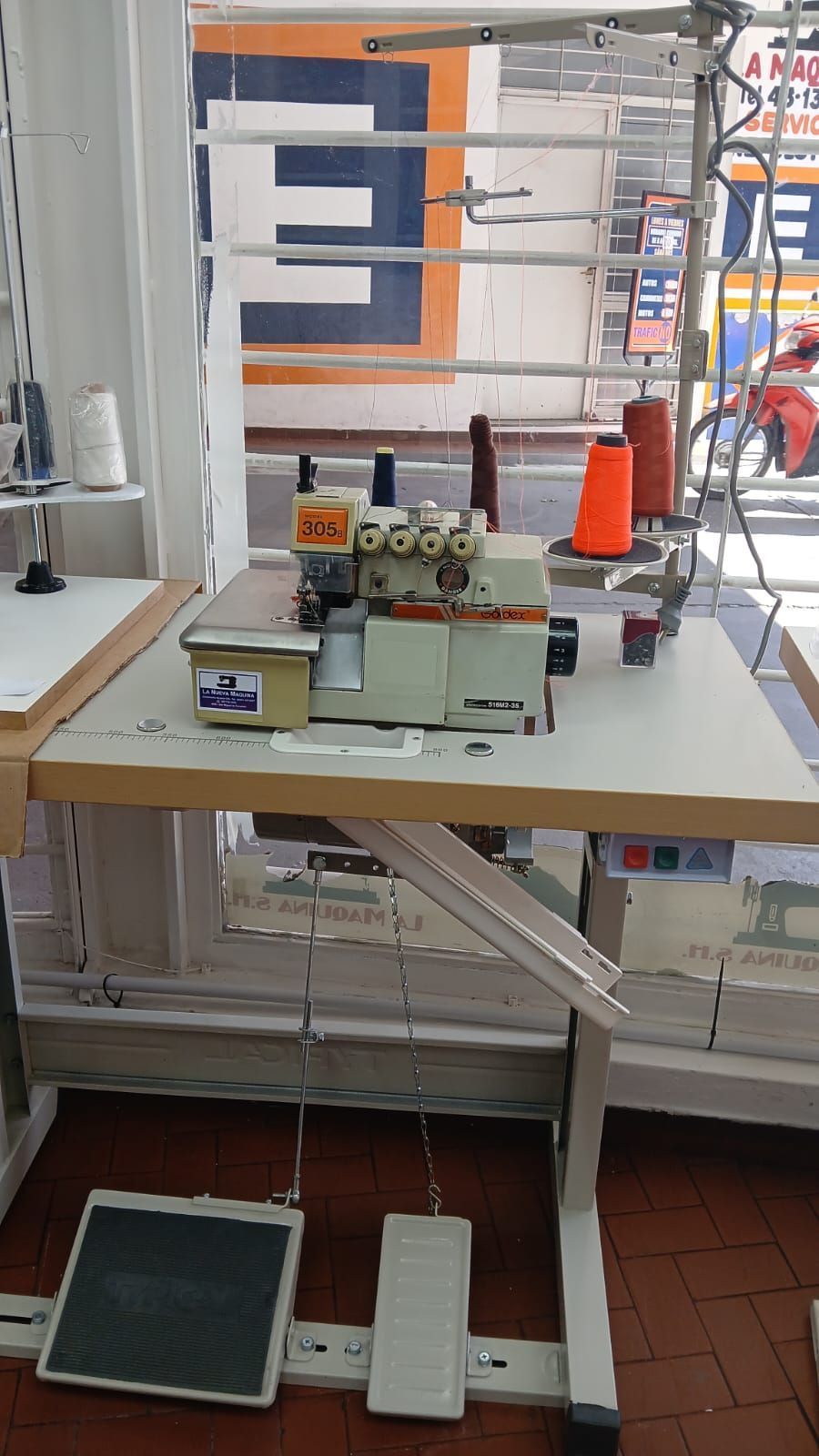 Banco de trabajo con herramientas y equipos variados cerca de una ventana en un taller o laboratorio.
