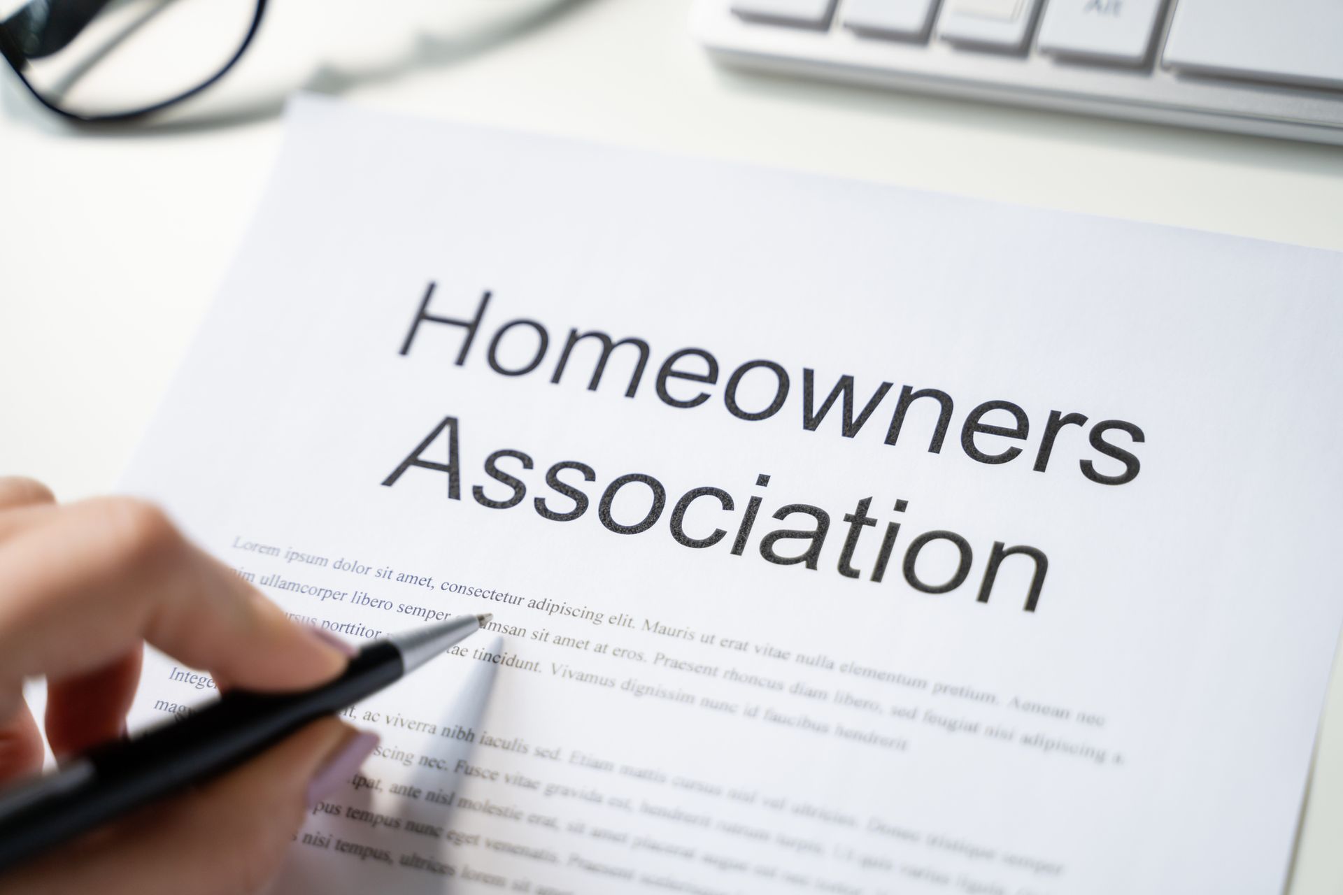 A person is writing on a piece of paper that says homeowners association.