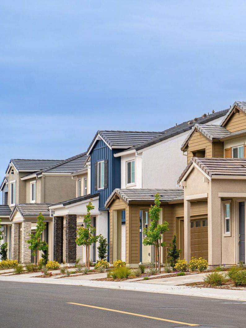 A row of houses are lined up on the side of a street.