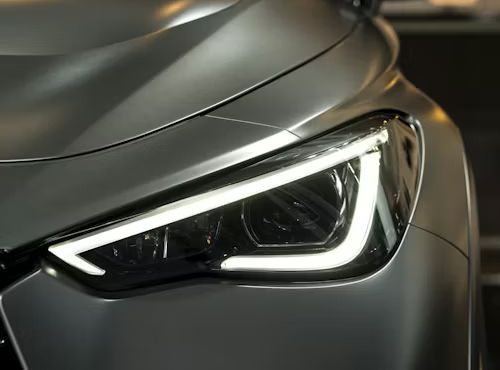 Close-up of a modern matte grey car's sleek LED headlight with a distinctive V-shaped daytime running light signature.