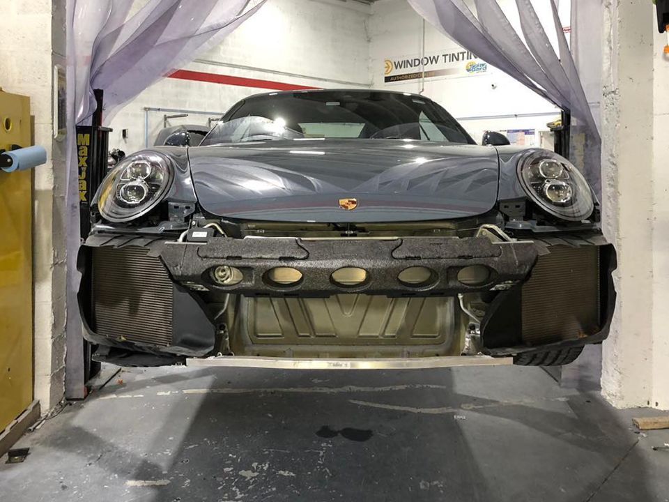 A car is being lifted into a garage by a curtain.