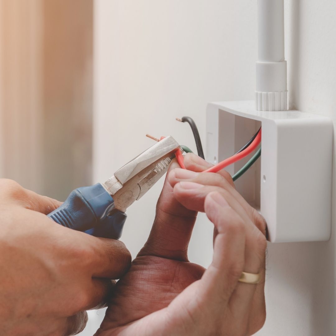 electrician cutting a wire with pliers