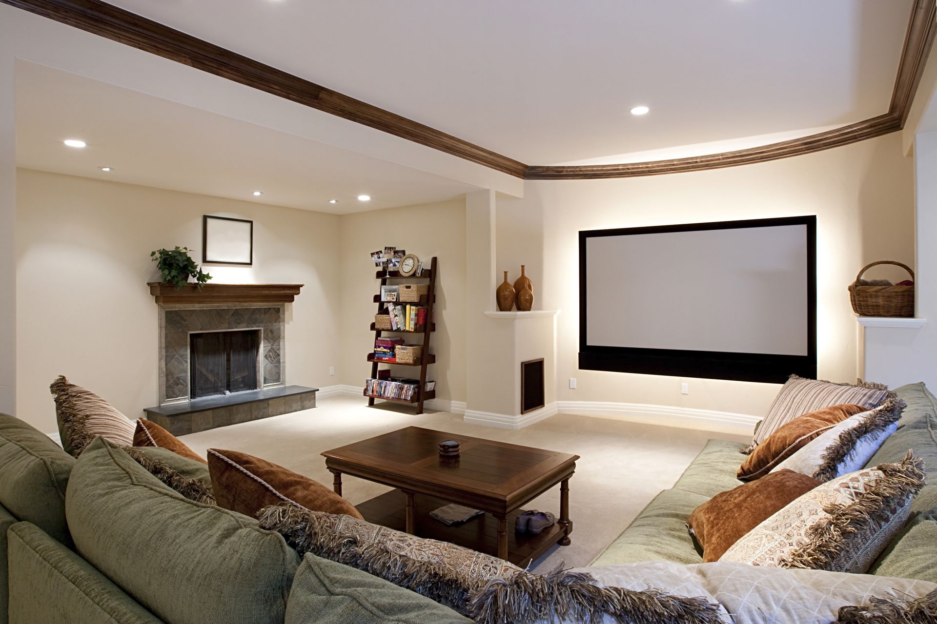 Cozy home theater with a large screen, fireplace, and comfortable seating. Beige walls, brown trim.