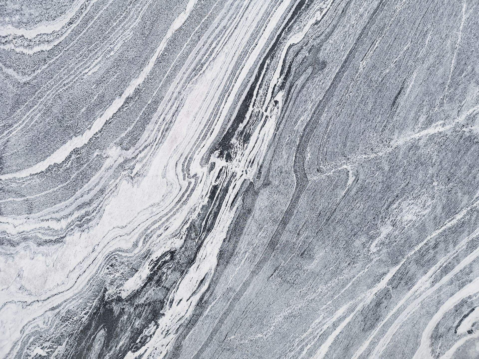 Gray and white marble with swirling, linear patterns.