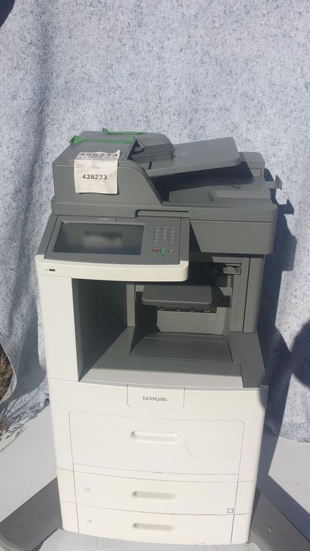 White and gray office copier/printer against a speckled backdrop.