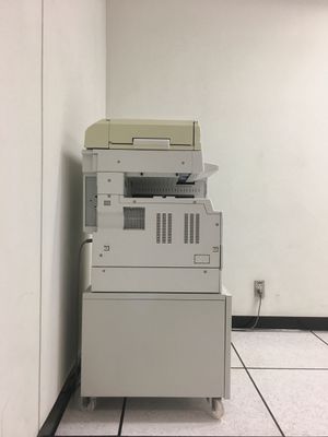 Office copier/printer against a plain wall in a tiled room