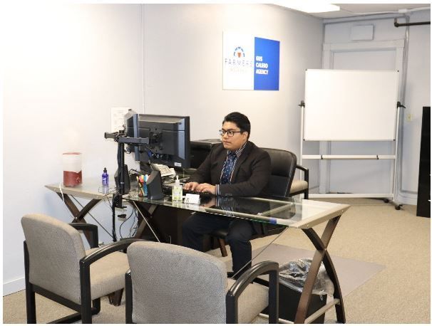 Insurance agent is sitting at a desk using a computer