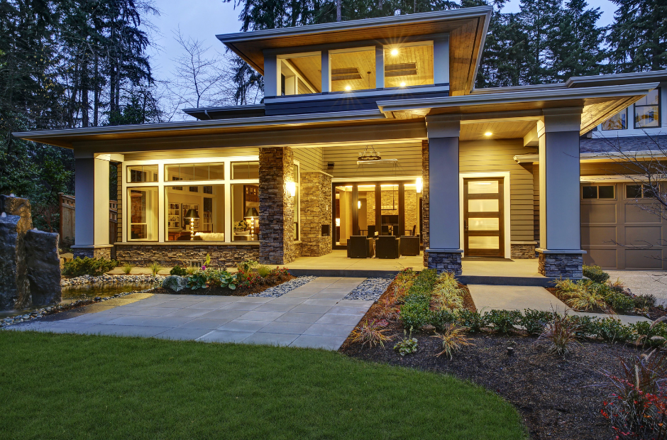 A large house with a lot of windows is lit up at night.