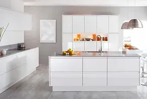 A kitchen with white cabinets and a large island in the middle.