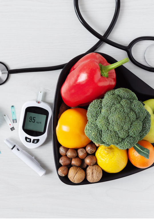 A heart shaped bag filled with fruits and vegetables next to a stethoscope.