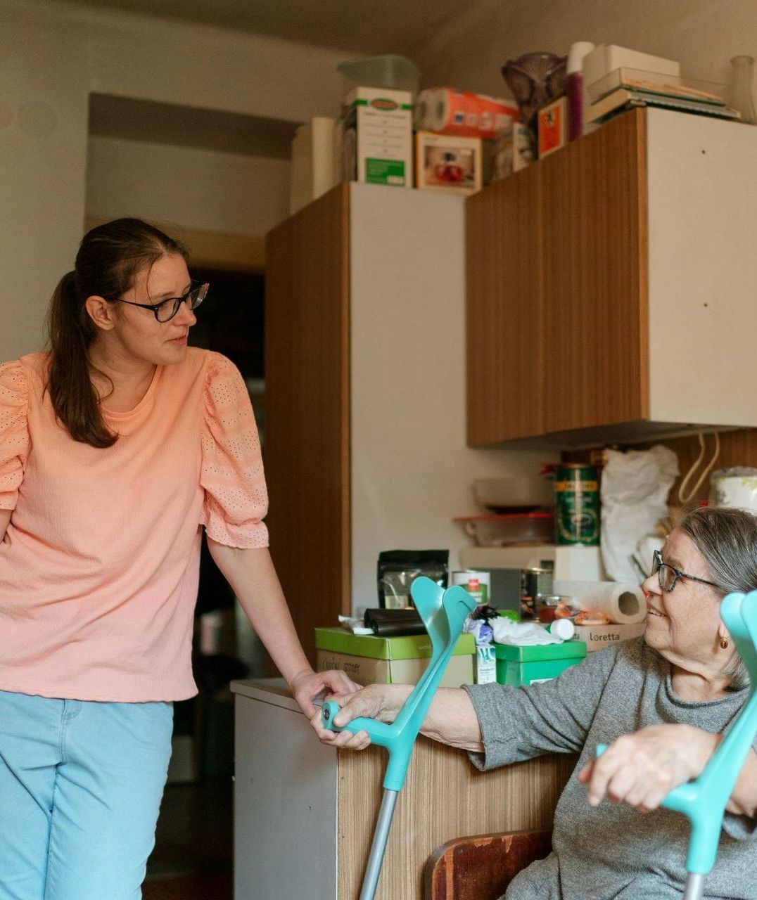 A woman is standing next to a woman with crutches