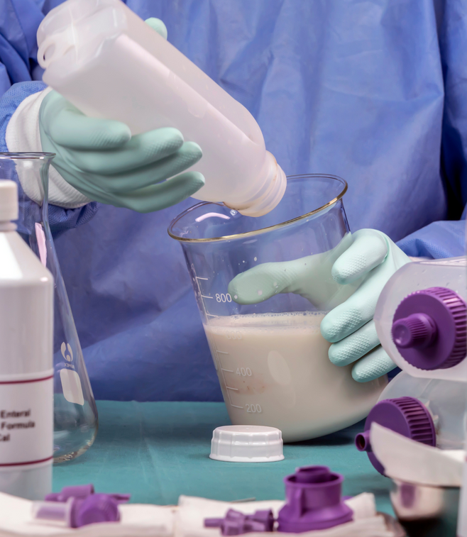 A person is pouring liquid into a beaker that says 500 ml