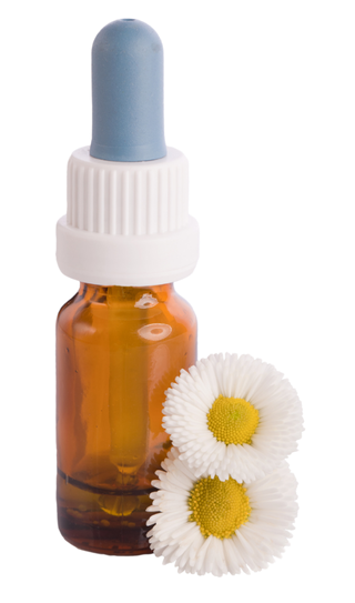 A bottle with a dropper and two daisies next to it