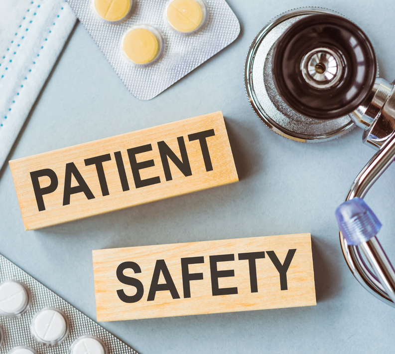A stethoscope , pills , and wooden blocks that say patient safety