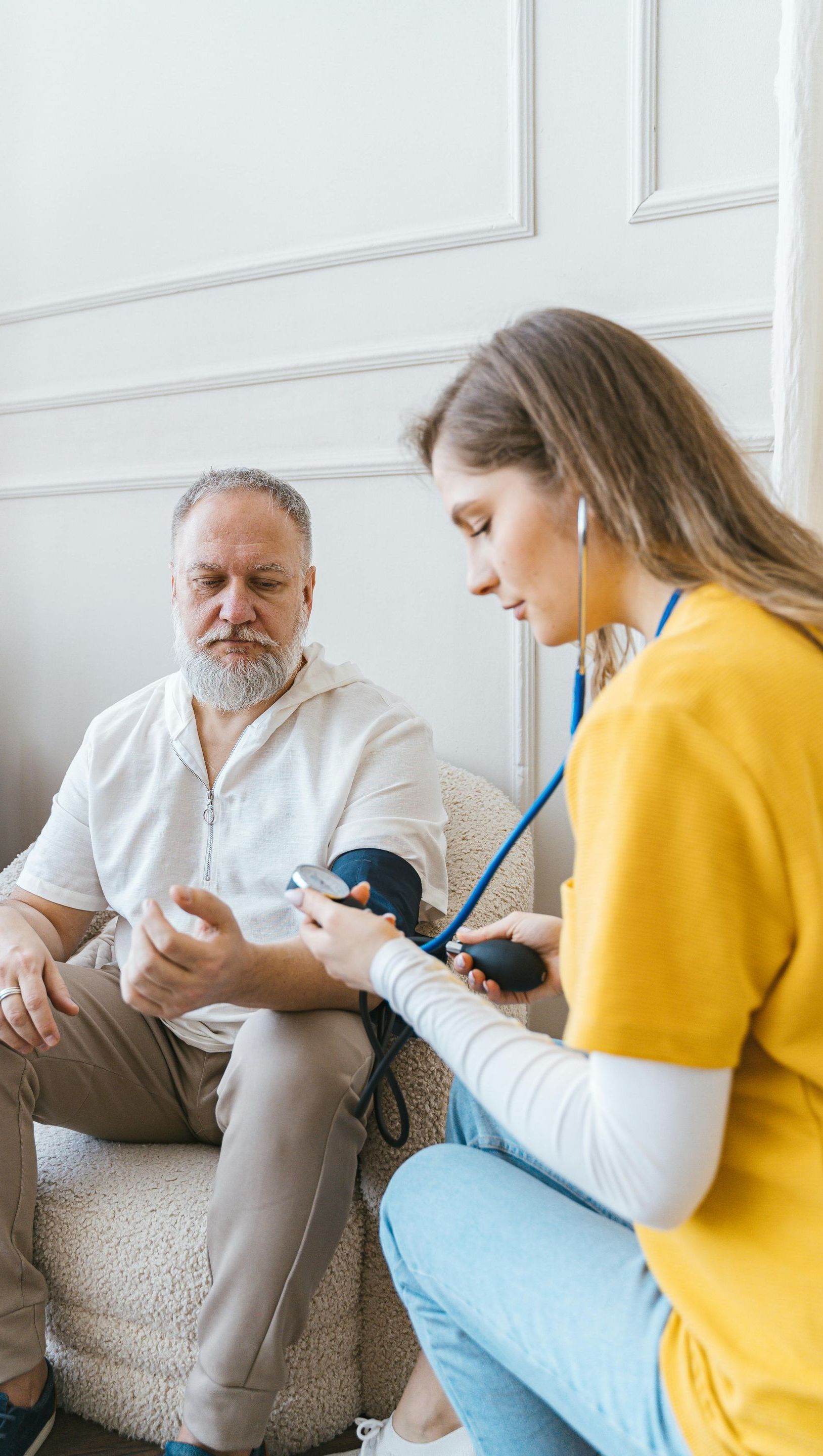 Home care nurse checking blood pressure