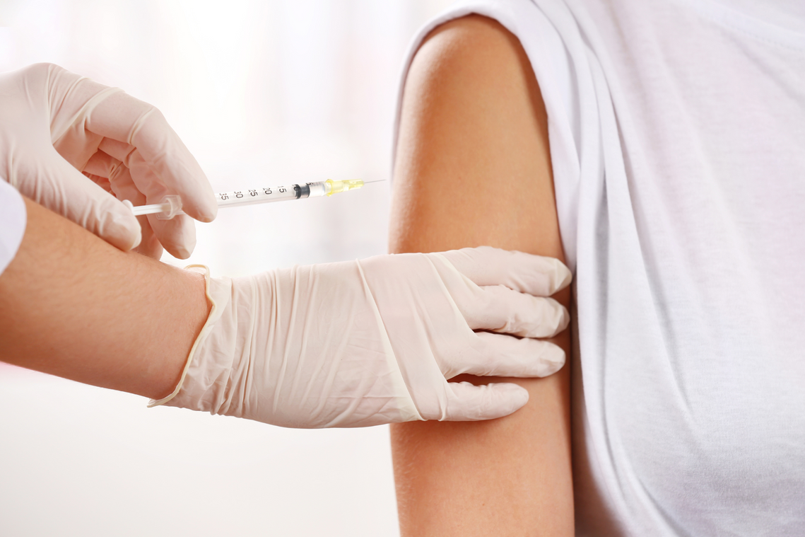 A woman is getting an injection in her arm.