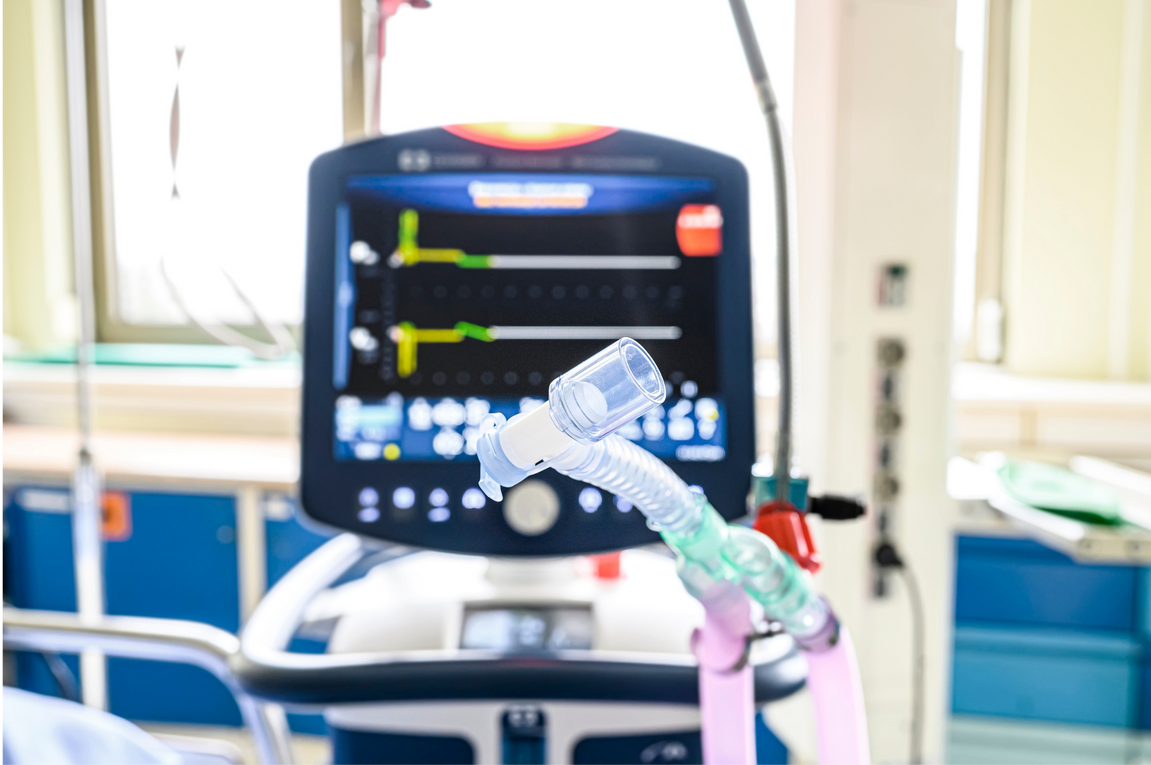 An oxygen mask is attached to a monitor in a hospital room.