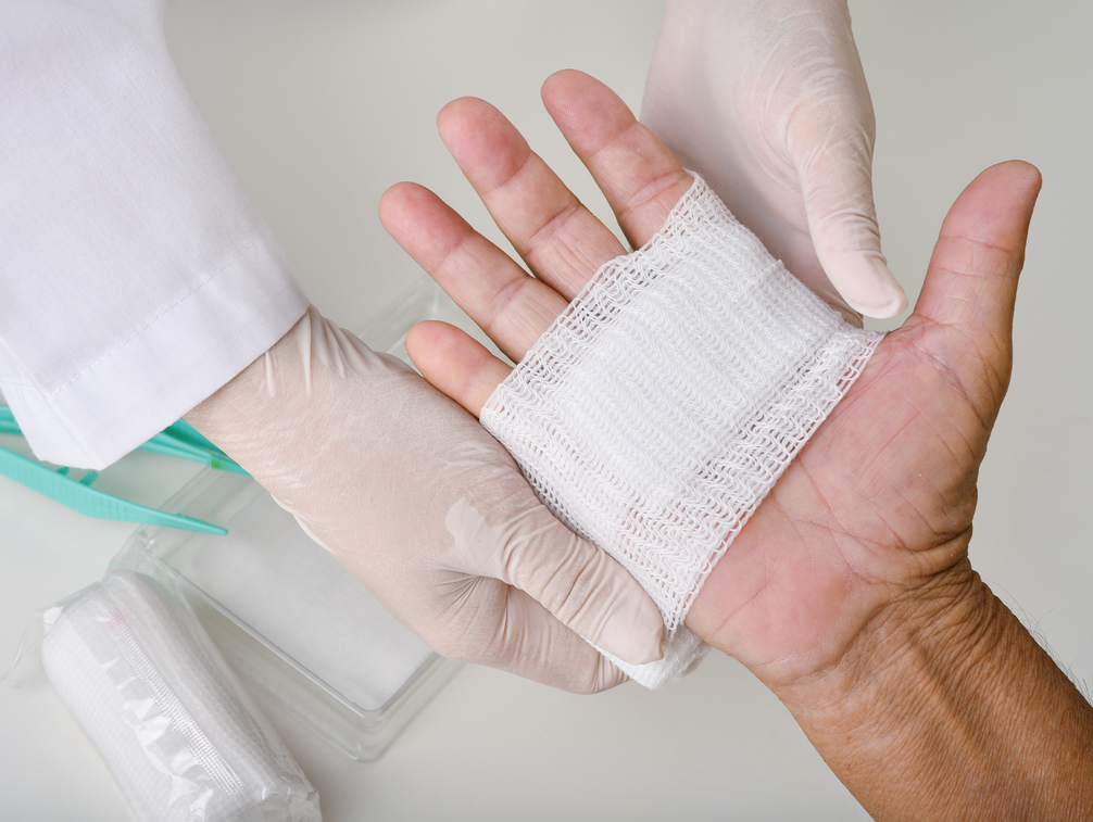A person is getting a bandage on their hand.