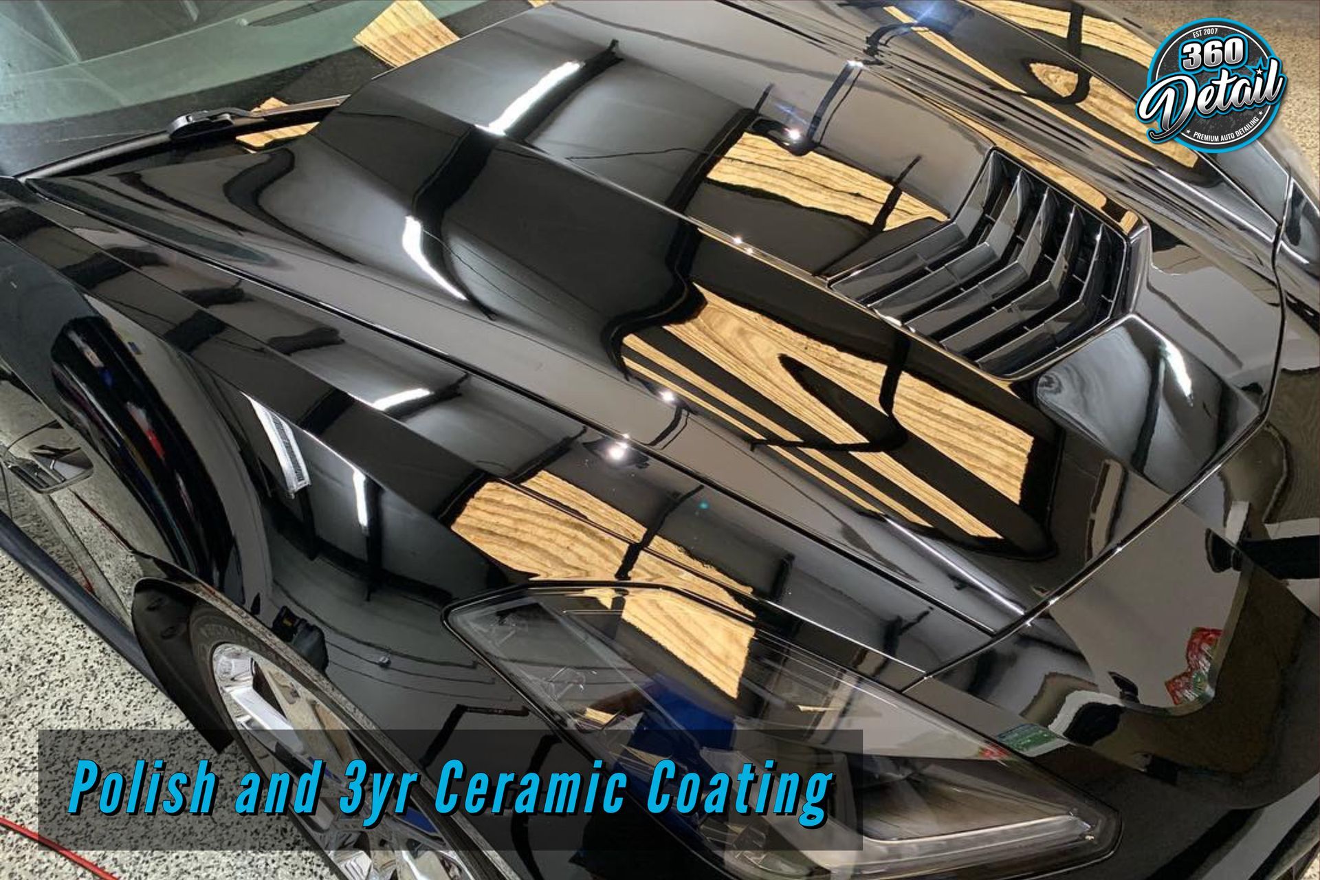 Black sports car hood with reflective shine after polish and ceramic coating.