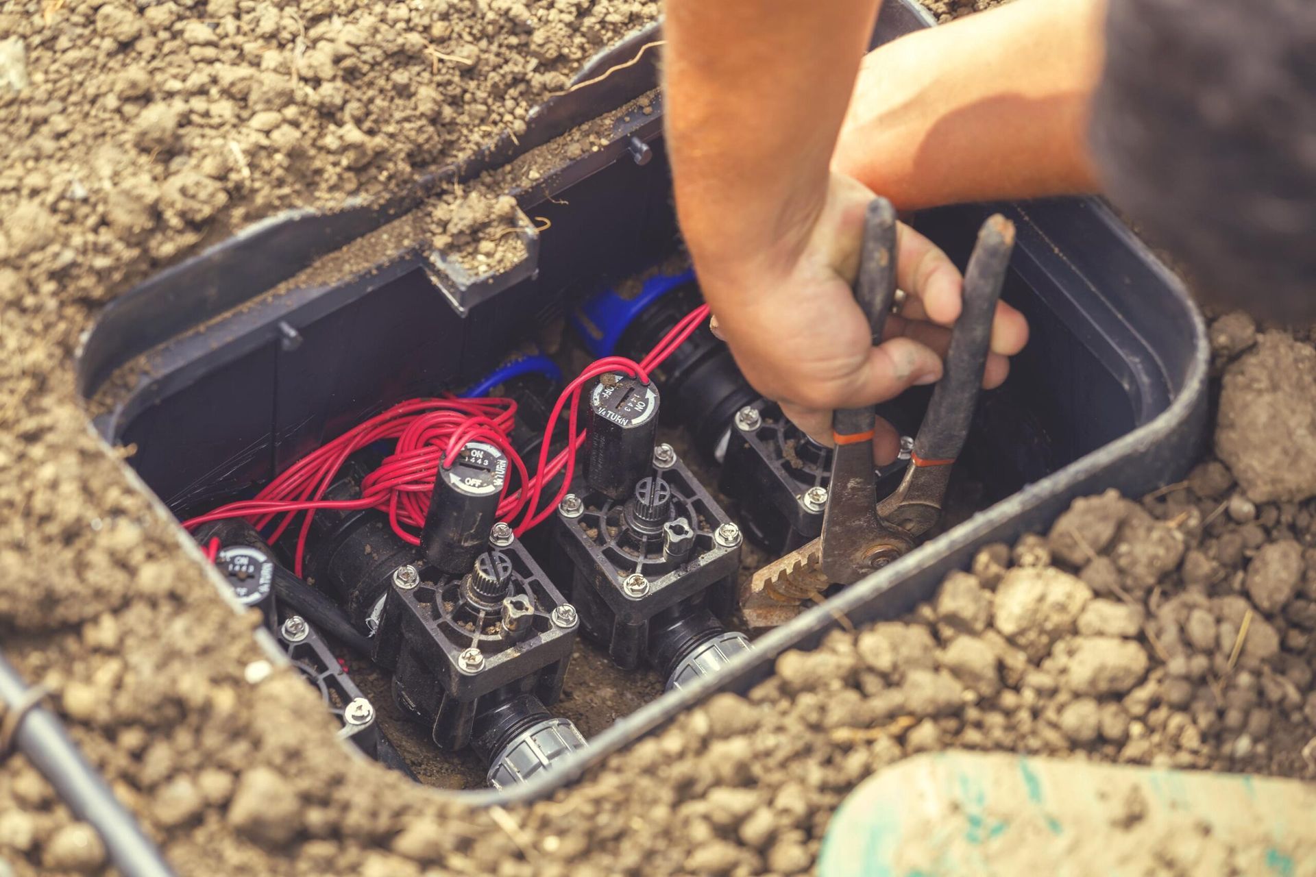Irrigation technician repairing a lawn irrigation system and broken sprinkler head.