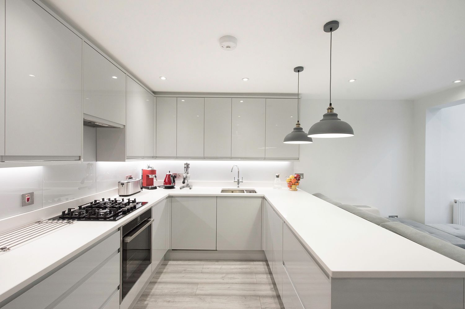 A kitchen with white cabinets and a stove top oven