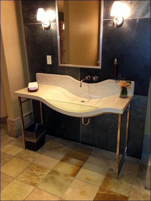A bathroom with a curved sink and a mirror