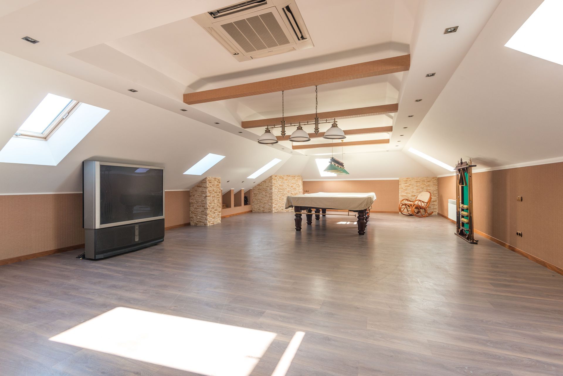 Large room with a sloped, gray modular surface and a person standing near the far end.