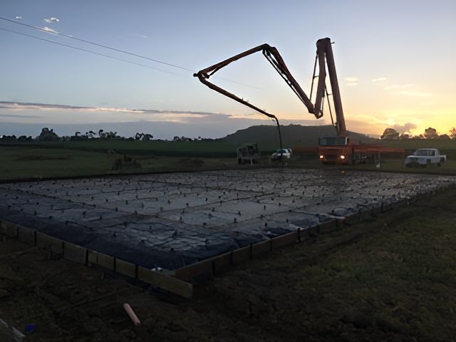 A Concrete Pump Is Being Used To Pour Concrete Into A Field — S & K Gallaway Concreting In West Mackay, QLD