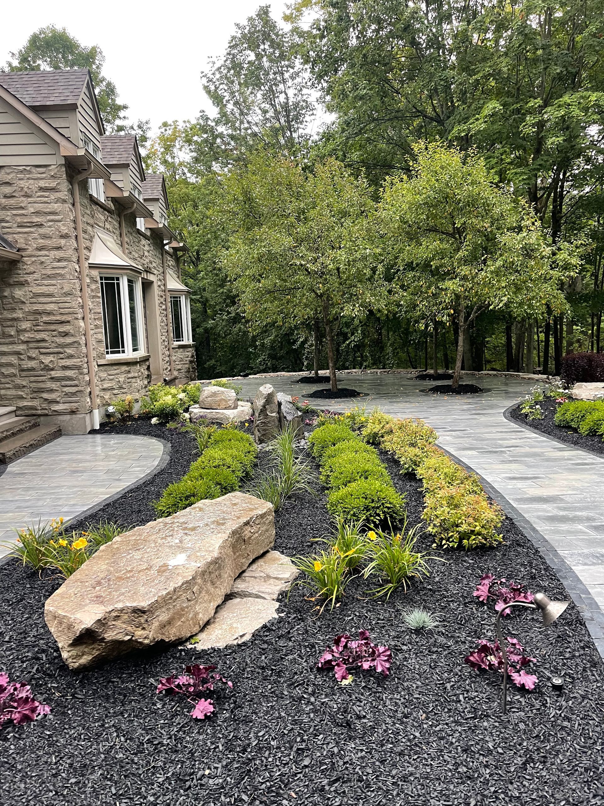 There is a large rock in the middle of the garden.