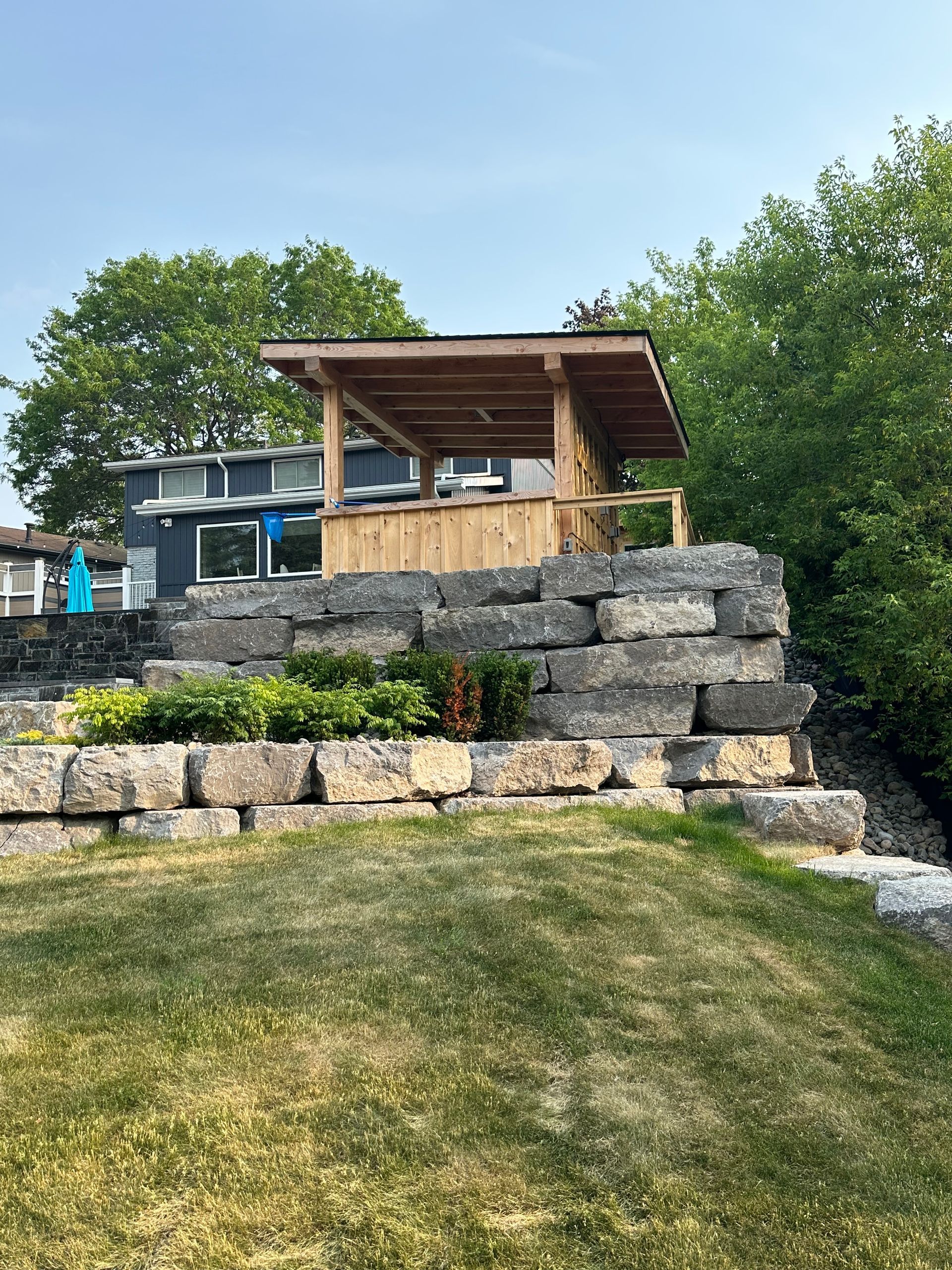 A wooden structure is sitting on top of a rock wall.