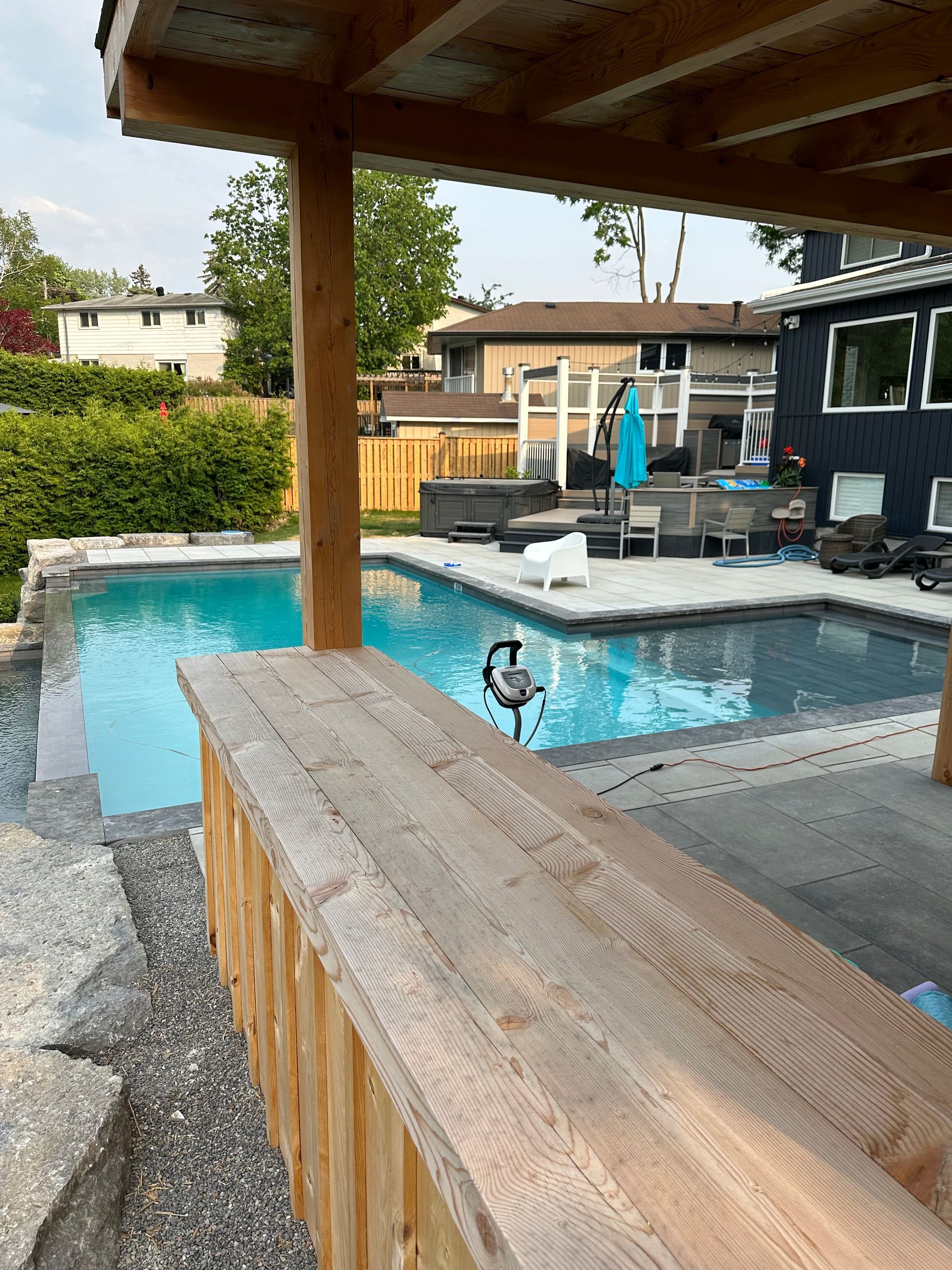 A large swimming pool is surrounded by a wooden fence.