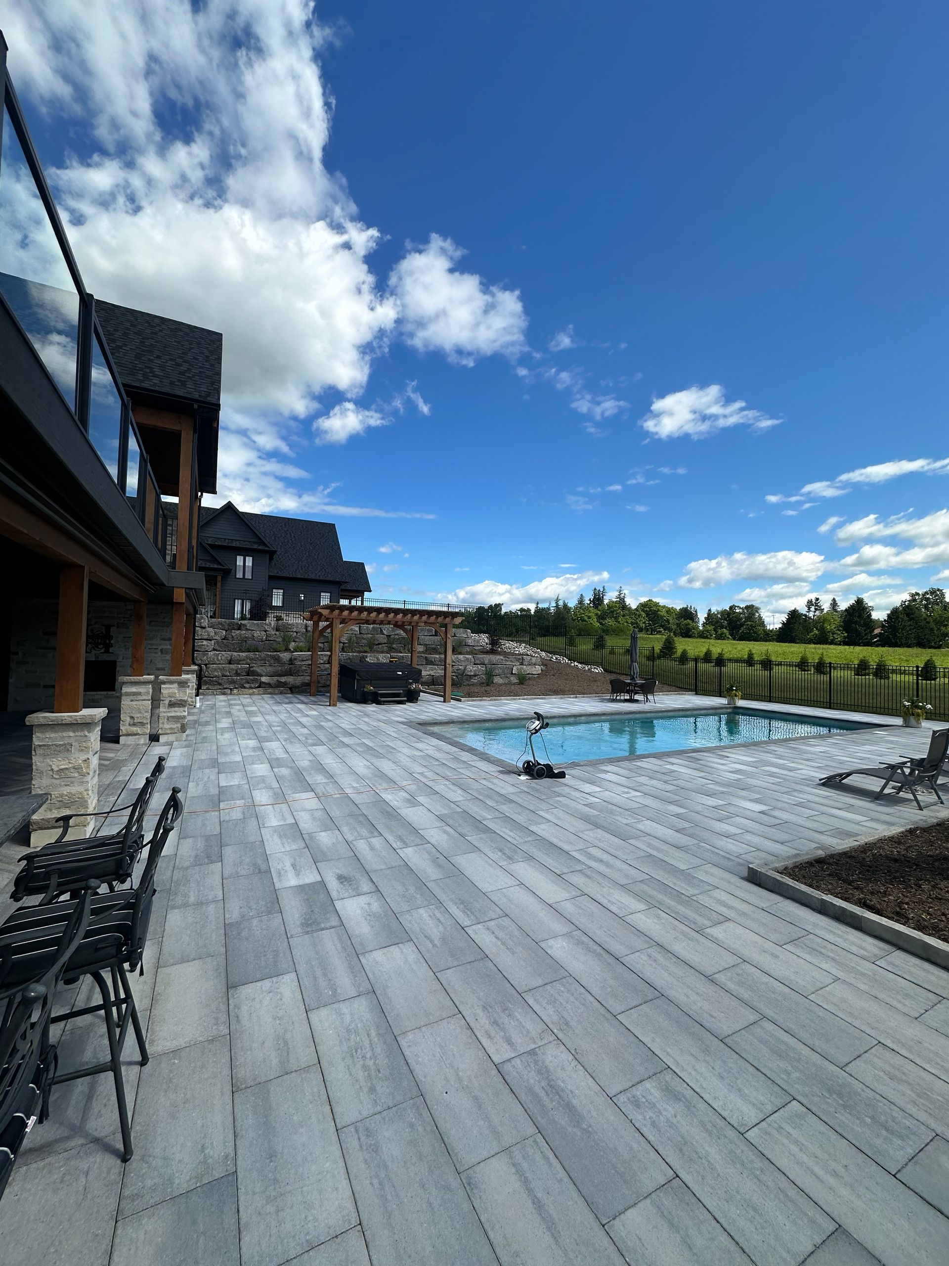 A large patio with a swimming pool in the background