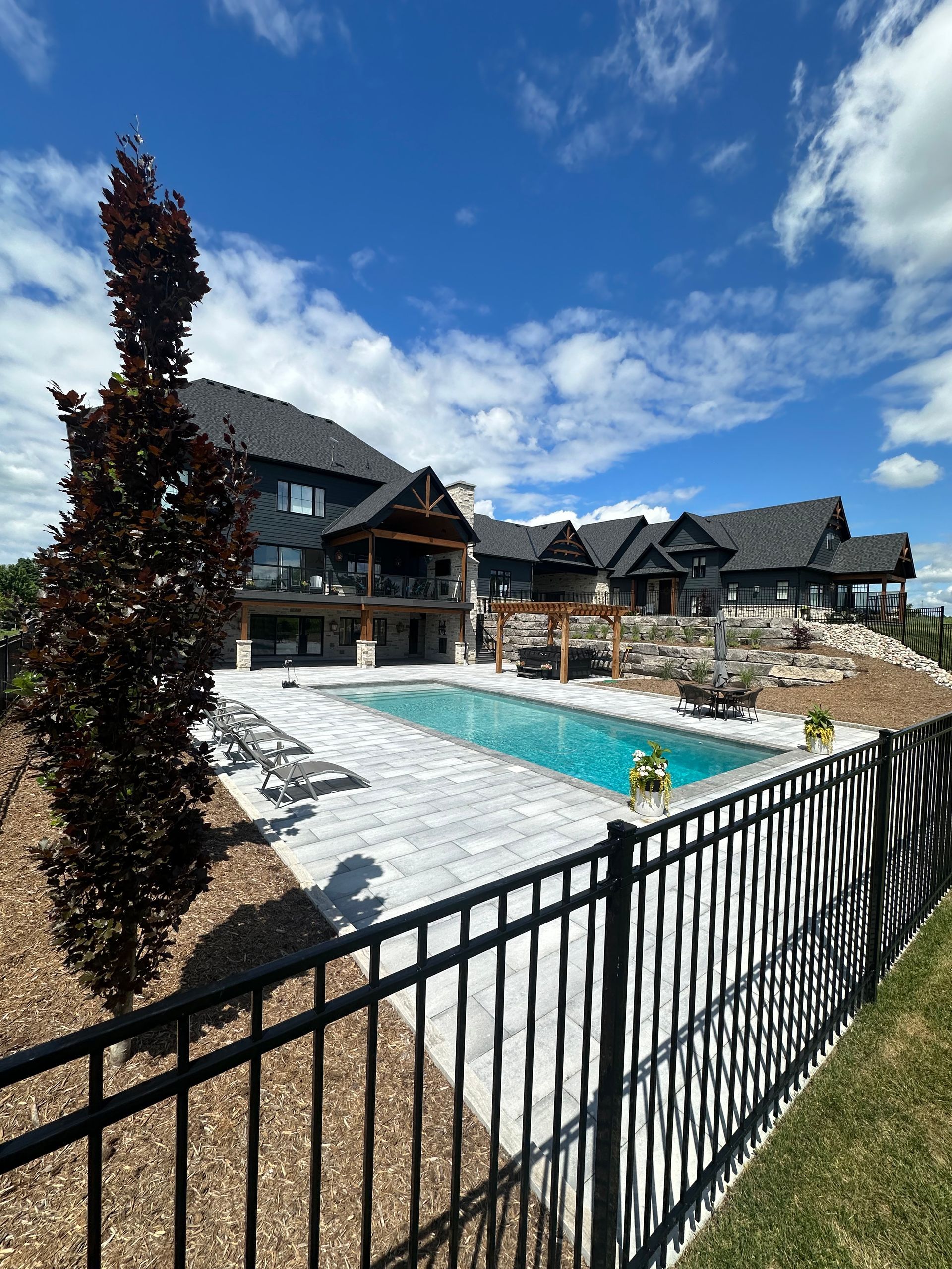 A large house with a large swimming pool in front of it.