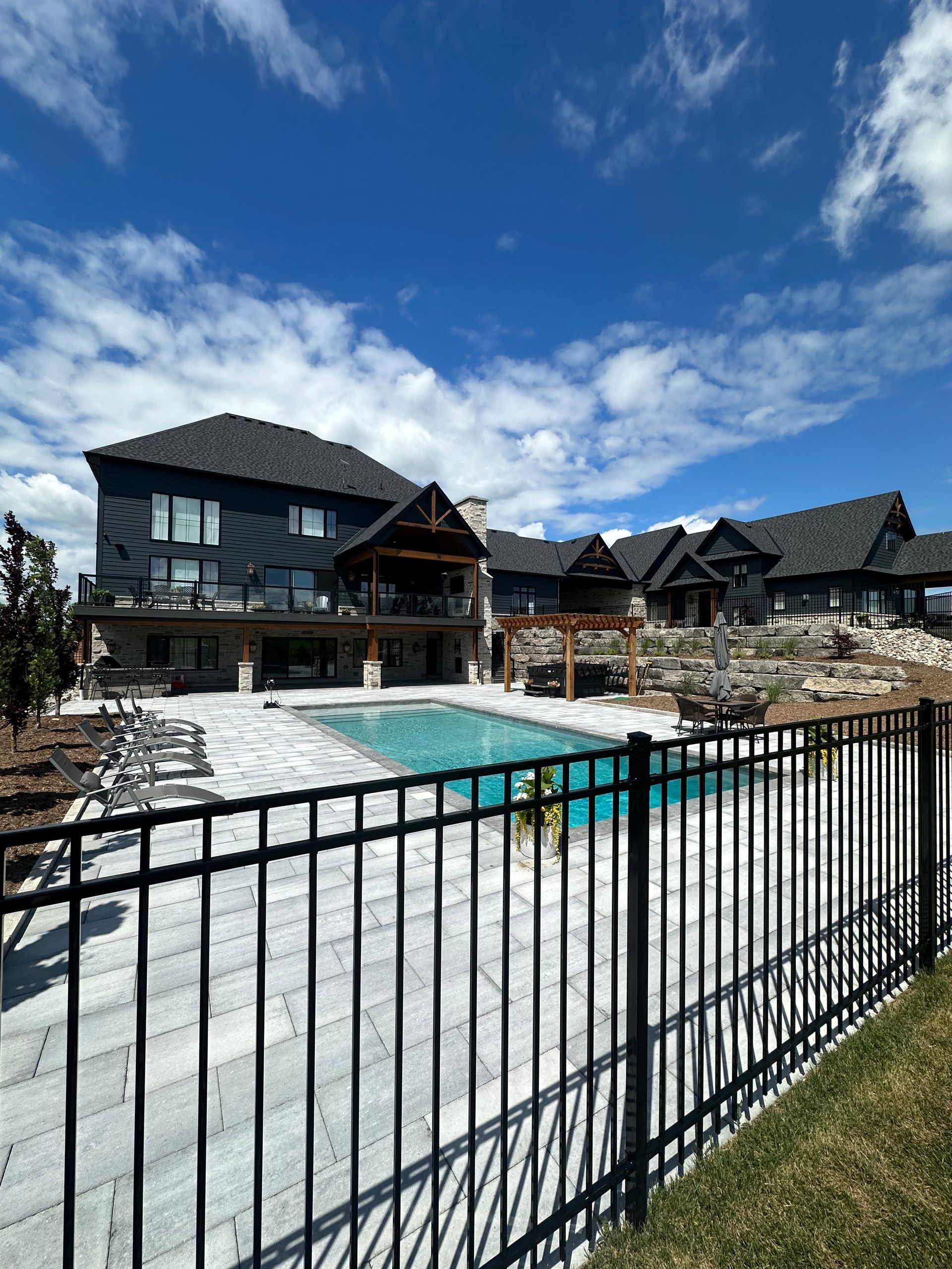 A large house with a swimming pool behind a fence