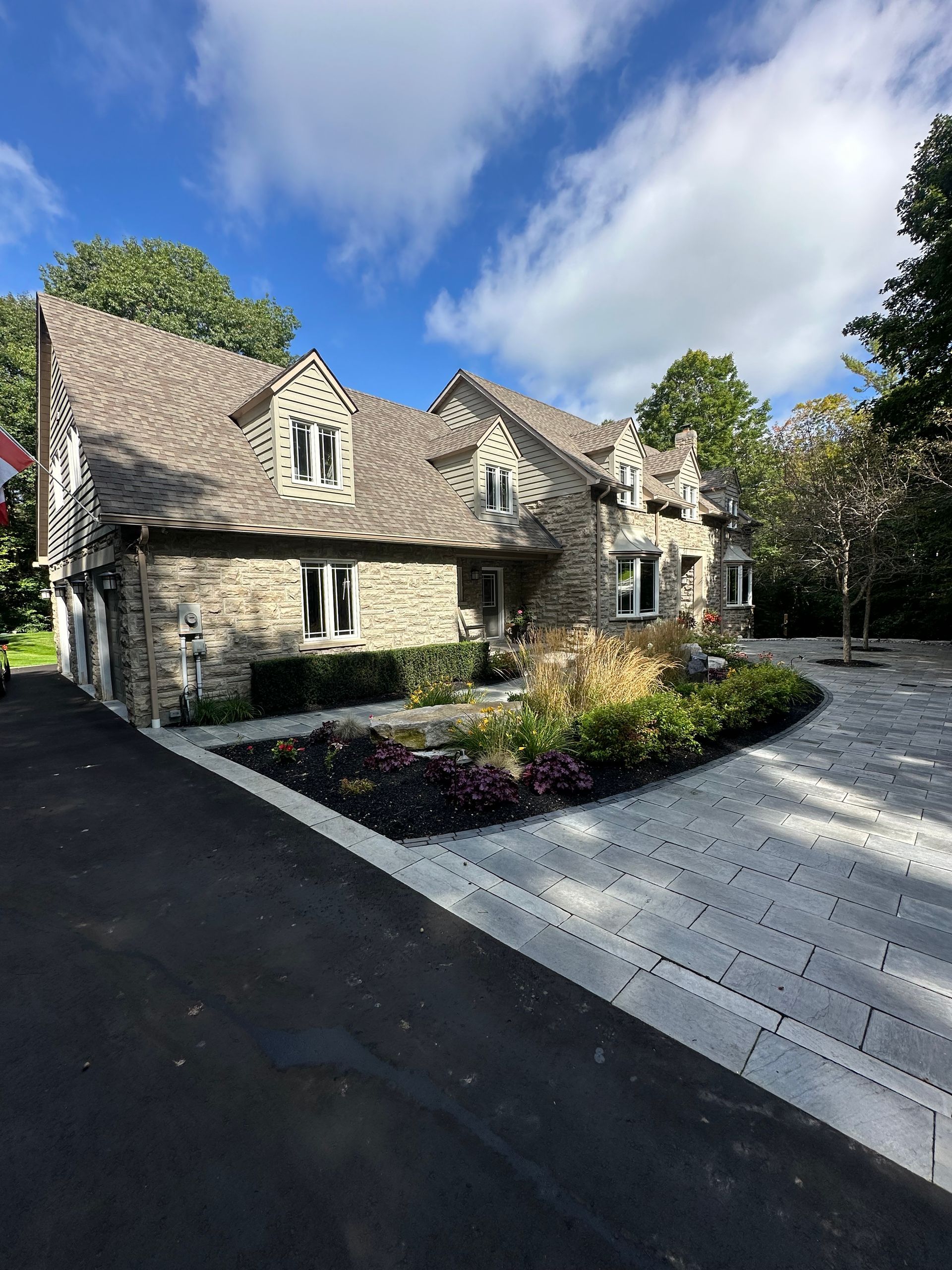 A large house with a lot of windows and a driveway in front of it.