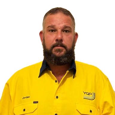 Portrait of a bearded man in a yellow work shirt with a dark collar, facing forward against a white background