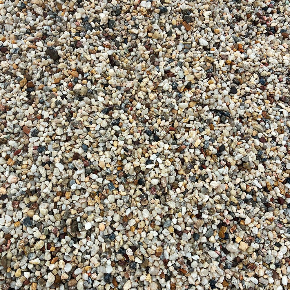 A close-up of a mixed gravel surface with small gray, tan, white, and brown stones.