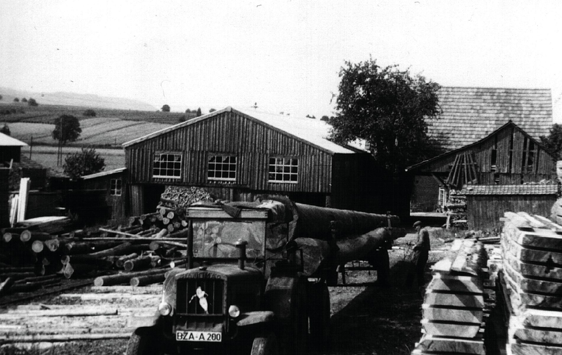 Ein Historisches Bild von 1931 auf dem das Gelände mit der Werkhalle und im Vordergrund ein Traktor zu sehen ist.